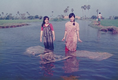 Kayoko and another woman washing fabric in a river to remove excess dye.