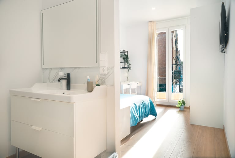 "Un baño con un lavado y una cama dentro."