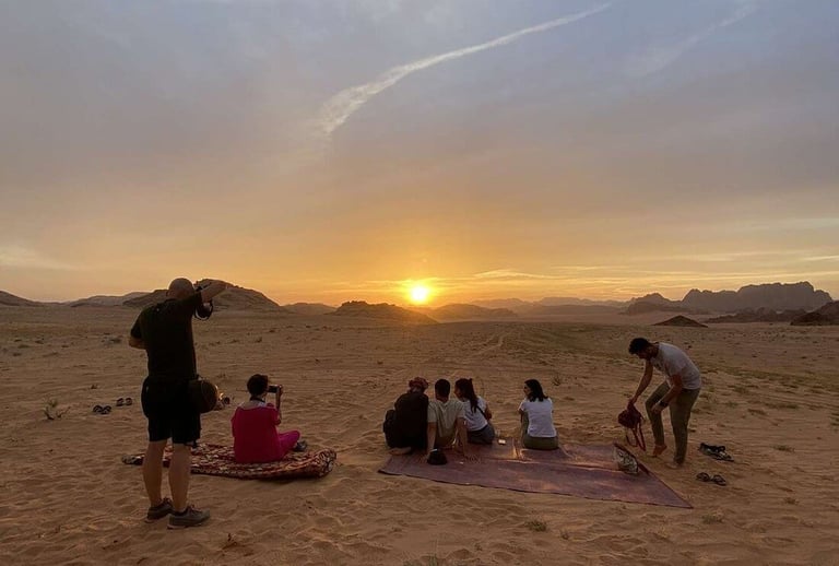 a group of people sitting on a blanket in the desert