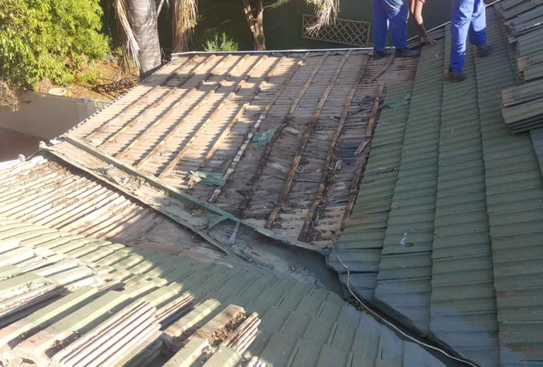 Non-compliant roof showing exposed battens and deteriorated waterproofing.