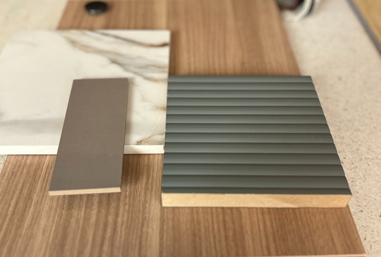 Interior design mood board featuring wood grain samples, marble tile, and fluted grey cabinetry panels.