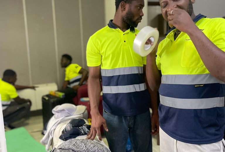 A team of four professional movers in yellow high-visibility polos with reflective stripes and "Safe