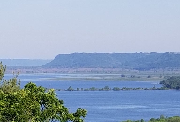 a wide river with a bluff in the background