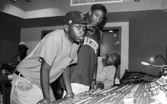 Black and white photo of A Tribe Called Quest members working at a professional recording studio mixing console