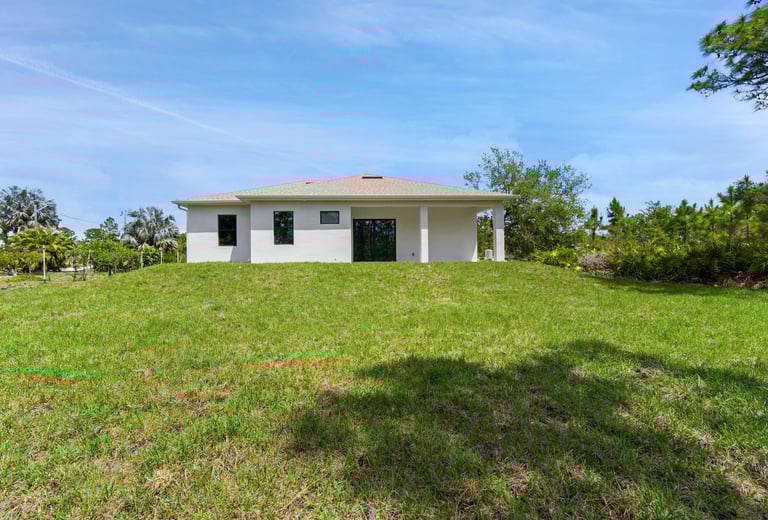 Exterior view of the back of the house, featuring porch and landscape