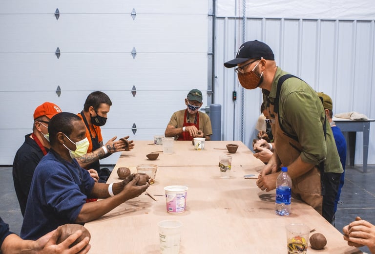 Image of an instructor leading a clay project in front of our Veteran class.