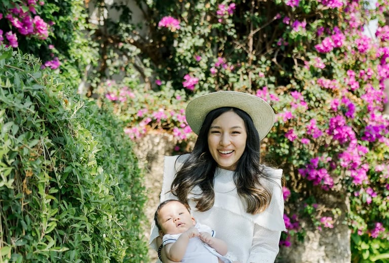 Mother carrying her baby in the tropical gardens of Samabe Bali Suites & Villas in Nusa Dua.