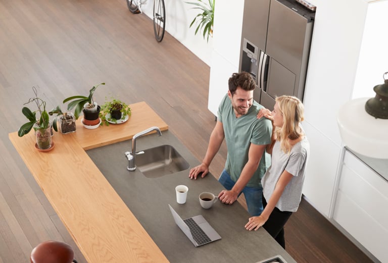 a man and woman standing in a kitchen