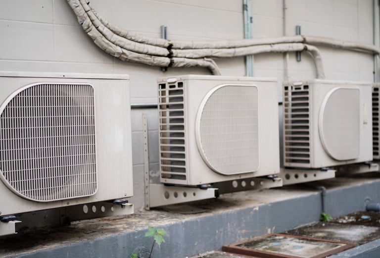 a group of air conditioners sitting on a ledge