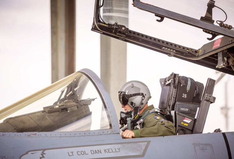 a man in a pilot's helmet sitting in an f-16 fighter jet