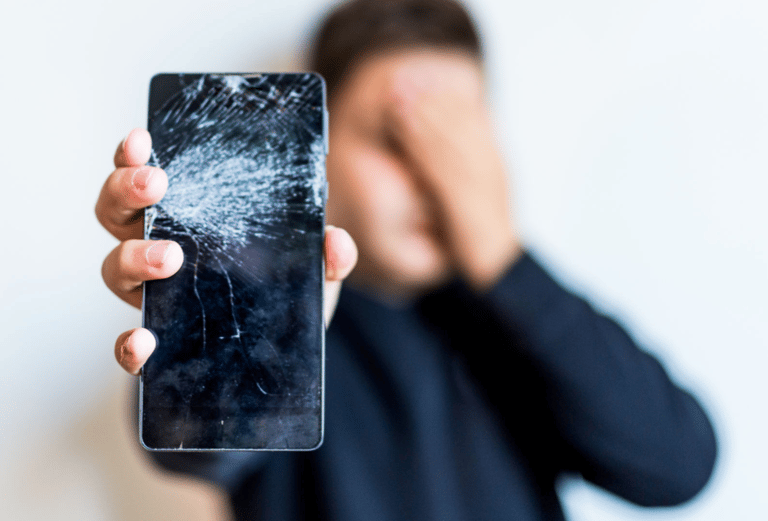 a man holding a phone in front of a broken phone