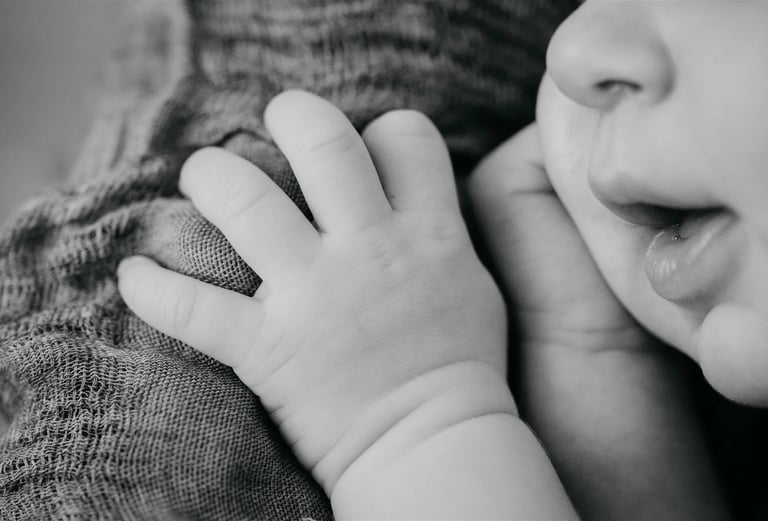 Détail en noir et blanc de la bouche et de la main d’un nouveau-né – photo naissance Gard
