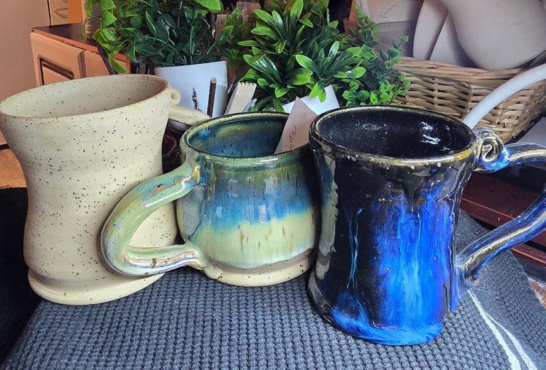 a table with a bunch of different colored mugs