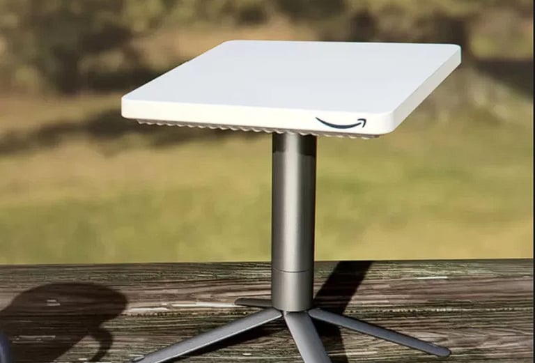 Amazon Project Kuiper satellite internet terminal mounted on a wooden surface with a grassy background.