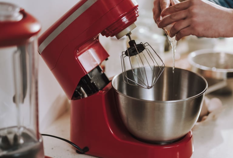 a person is holding a mixer and mixing a bowl