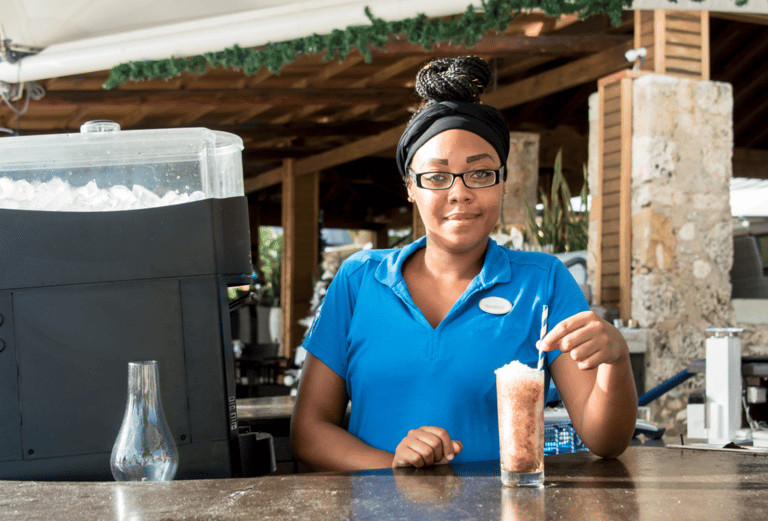 a woman in a blue shirt is holding a drink