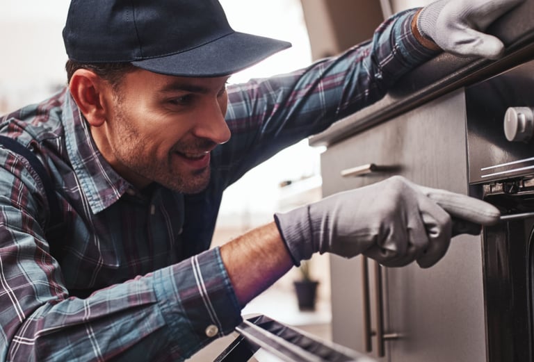a man in a hat and gloves is putting something in the oven