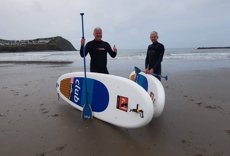 Derek 'The Weatherman' Brockway wituh paddle boards on Borth Beach.