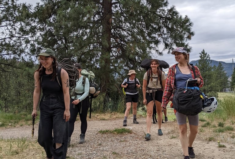 Group of people with climbing gear walking in a treed area