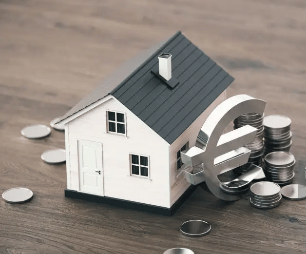 Petite maison à côté d'un gros sigle euros et entourée de pièces de monnaie
