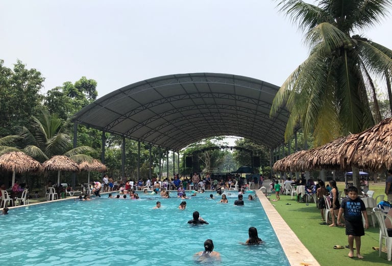 Families swimming in pool at Centro Recreacional Mokanrankon with a large arched metal roof