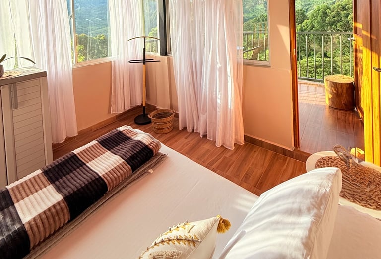 Habitación con cama doble, grandes ventanas con balcón