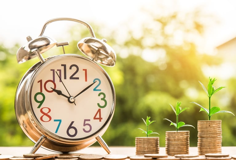 clock next to coins that grow in value more and more over time thanks to compound interest