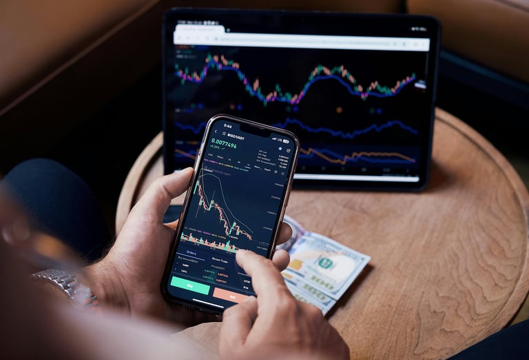 guy managing investments with phone and computer