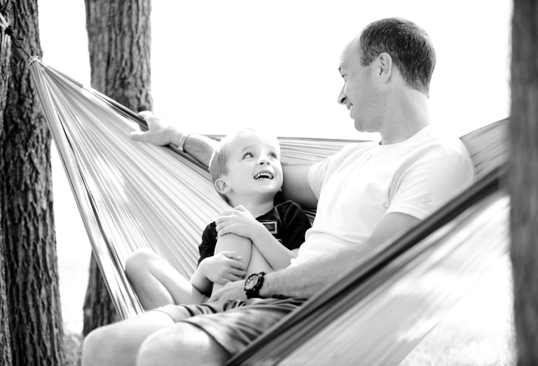 father and son talking on a hammock