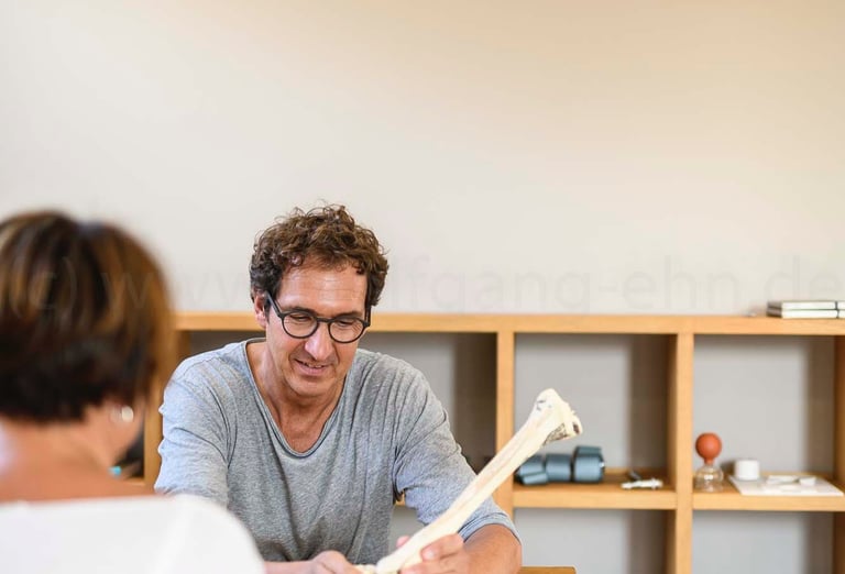 a man and woman sitting at a table with a book
