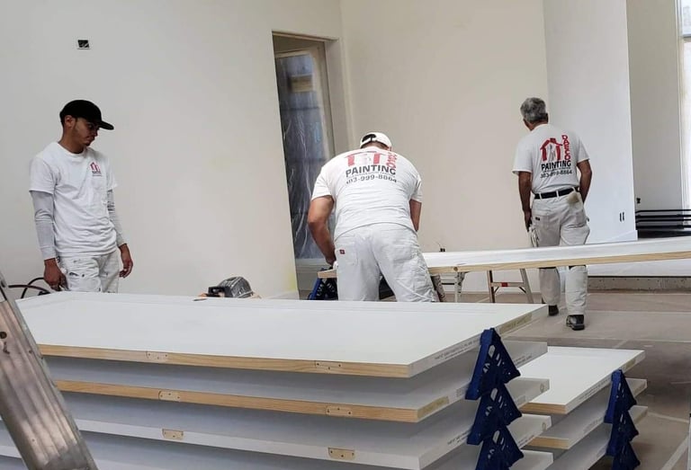 a group of daeco painters in white uniforms working on a interior doors