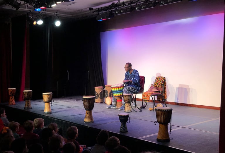 Artist Kofi Dennis performs for students at Discovery Theater in Washington, DC