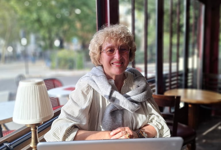 Mireille Bordet dans un café, face à son ordinateur, prête pour un entretien d'échange