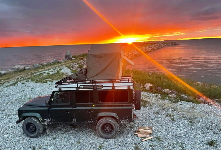 Roof tent on Land Rover with sunset 