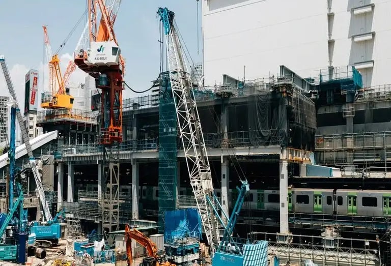 Heavy machinery and cranes working on a large scale site development and infrastructure project