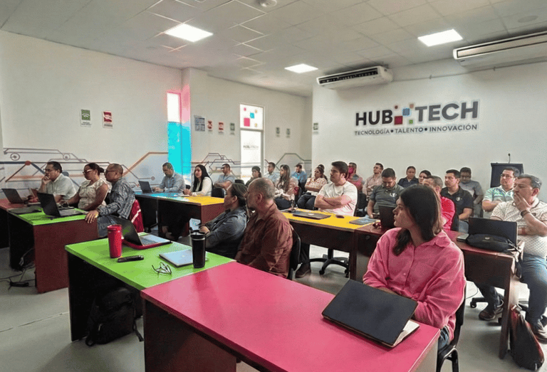 Students attending a technology workshop in a Hub Tech classroom with laptops and colorful desks.