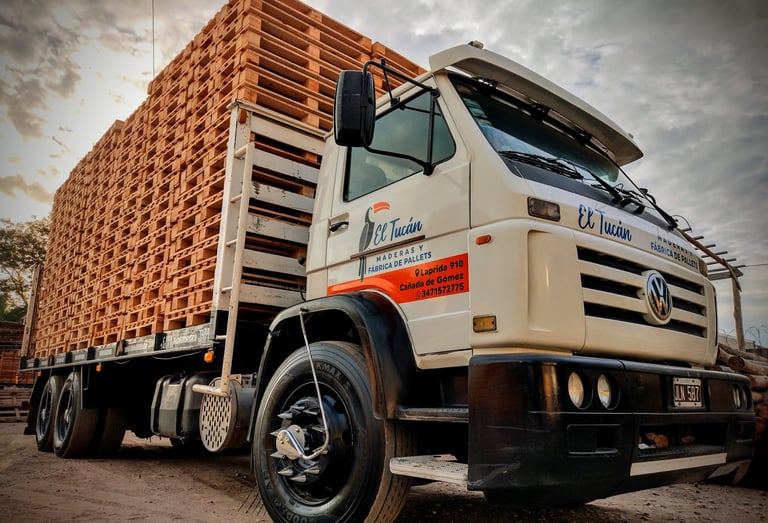 Camión cargado con pilas de pallets de madera nuevos para su transporte.