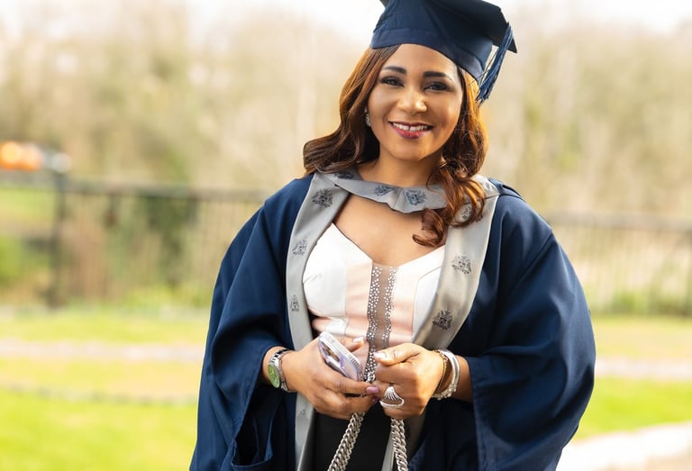 Smiling Black woman in a graduation cap and gown graduation photography Liverpool