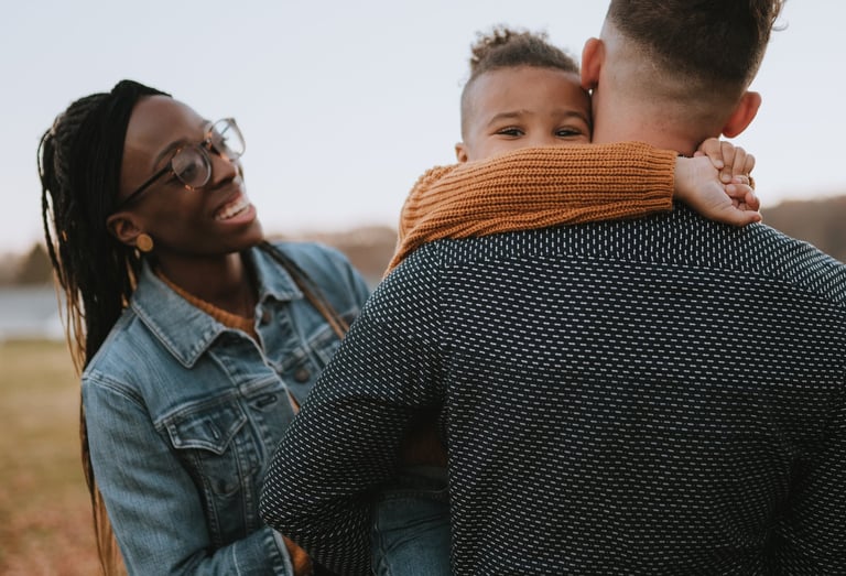 Family in field smiling with child