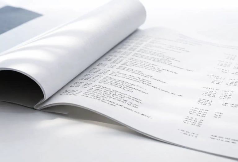 Open business report document showing financial data tables and printed spreadsheet pages.