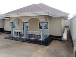 Bungalow moderne de plain-pied avec toit en croupe et porche voûté décoré de garde-corps blancs.