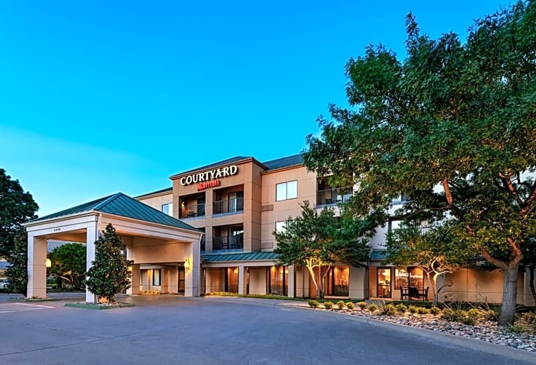 a hotel with a large courtyard and a parking lot