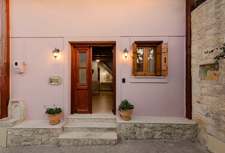 Tonia's Cottage entrance door open, logo sign and purple flowers