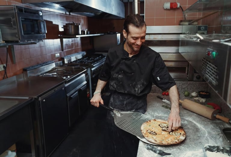 Šefas restorano virtuvėje ruošia šviežią gurmanišką picą