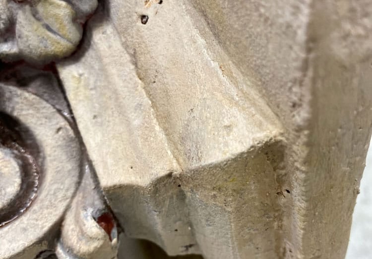 Close-up on capital of column with a painted sandstone faux finish.