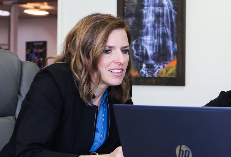 a woman sitting at a table with a laptop