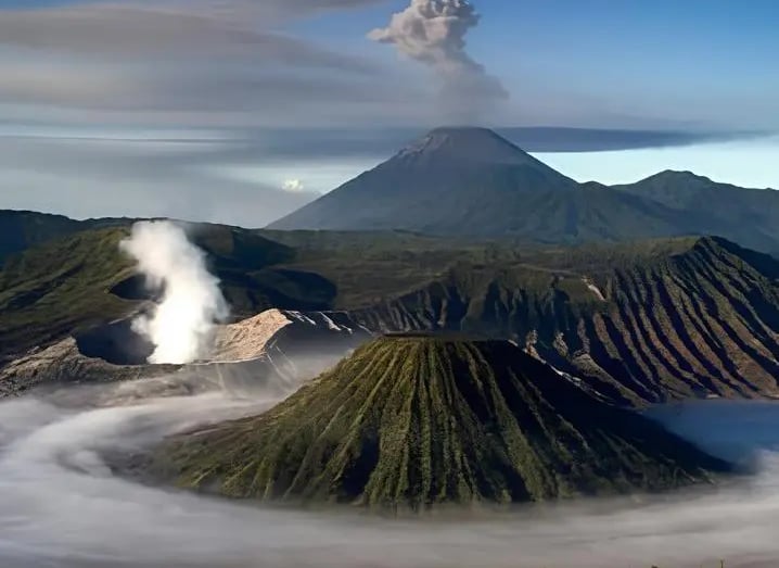 Pemandangan matahari terbit Gunung Bromo, Gunung Batok, dan Gunung Semeru yang berasap di Jawa Timur