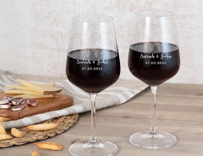 two wine glasses with wine glasses on a table