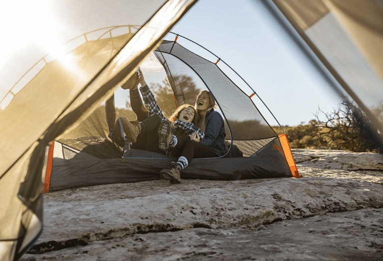 a woman sitting in a tent with her dog