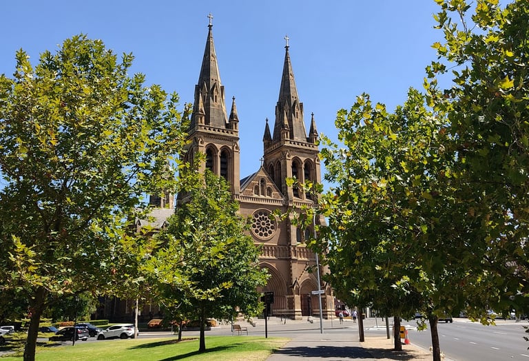 cobblestone church in the city centre of Adelaide with green trees and sunny day 
